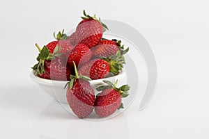 White bowl of fresh ripe red strawberries