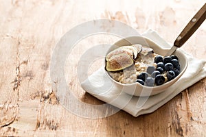 White Bowl of oats porridge figs and blueberries. Healthy oatmeal breakfast