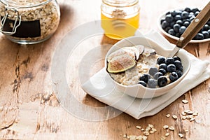 White Bowl of oats porridge figs and blueberries. Healthy oatmeal breakfast