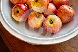 White bowl with red apples