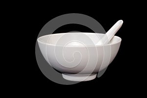 White bowl with spoon isolated on black background