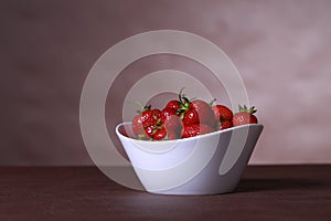White bowl of strawberries on the table