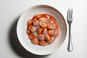 White bowl with tomato potato gnocchi