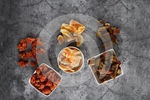 White bowls of candied rheum, pumpkins and cantaloup rock melon isolated on grey background flat lay
