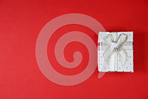 White box with bow on red background, Christmas gift isolated