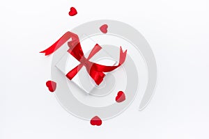 A white box with a gift in small red hearts on a white background, a template for Valentines day with a copy space, a