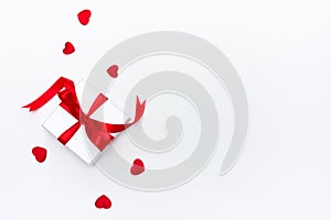 A white box with a gift in small red hearts on a white background, a template for Valentines day with a copy space, a