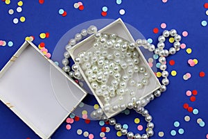 In a white box lies pearl beads