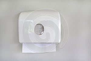 White box of tissues on wall in toilet