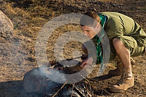 White Boy Scout Making Fire for Cooking at Camp