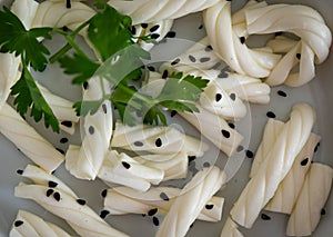 White braided cheese with black sesame served in a white plate