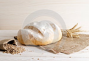 White bread with grains and wheat spikelets lying