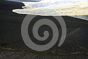 White breakwater foam hit on lonely black lava sand beach at Pacific coastline - Cobquecura Piedra De La Loberia, Chile