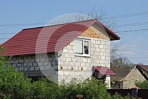 White brick  private house with a window under a red tiled roof
