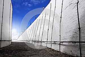 White brick wall against blue sky