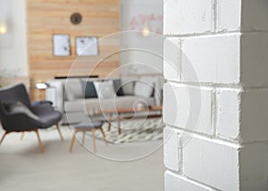 White brick wall and blurred living room interior