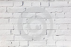 A white brick wall with a few bricks missing
