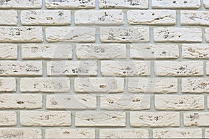 White brick wall with grain rough shabby porous stone. Decorative wall decoration, backdrop texture background. White limestone