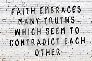 White brick wall with painted black inscription of wise quote