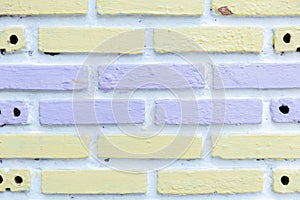 White brick wall painted with soft purple and yellow background texture