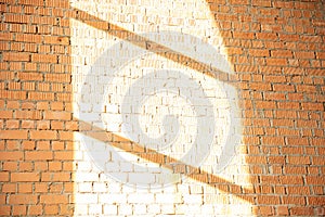 White brick wall with shadow and rays of light from the window