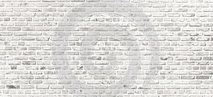 White brick wall. Simple grungy white brick wall with light gray shades pattern surface texture background in wide panorama format photo