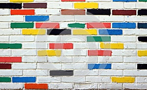 White brick wall, with some bricks painted randomly with other colors