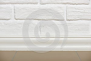 White brick wall with tiled floor closeup photo, abstract background photo