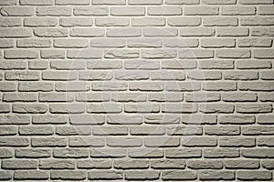 White brick wall of a warm shade lit from above by a lamp. White brick wall, perfect as a background, square photograph