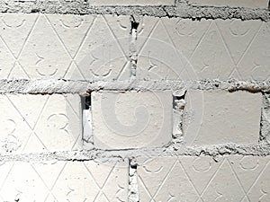 White bricks painted with diagonal lines and the number three.  Fragment of the wall.  Abstract textural background
