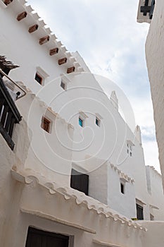 White bright houses with wooden windows on a typical Mediterranean fisher village in Menorca, Spain