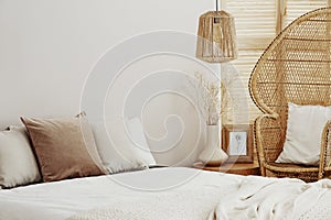 White and bright interior with wicker peacock chair and rattan lamp