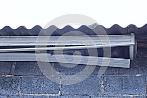 white broken plastic platbands under the roof of a house