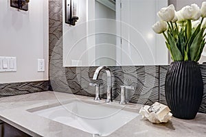 White and brown bathroom boasts a nook filled with taupe vanity