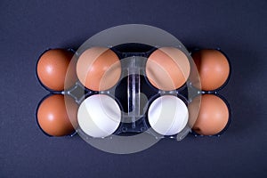 White and brown chicken eggs in a plastic package.