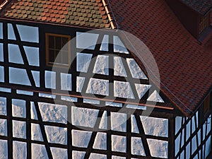 White and brown colored facade of historic half-timbered house with window and parts of the roof in village Bad Teinach.