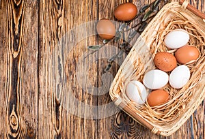 White and brown eggs in the basket on the table. Easter