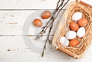 White and brown eggs in the basket on the table. Easter