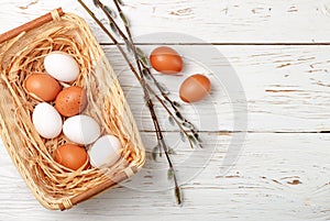 White and brown eggs in the basket on the table. Easter