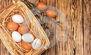 White and brown eggs in the basket on the table. Easter
