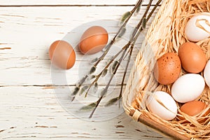 White and brown eggs in the basket on the table. Easter