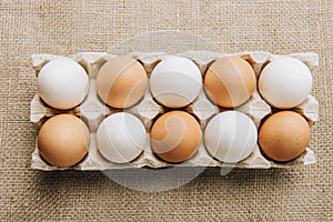 white and brown eggs laying in egg carton