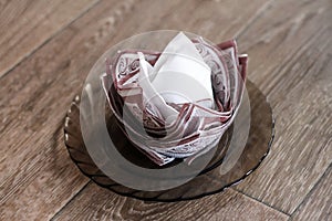 White-brown napkin in the form of a rosette on a wooden background