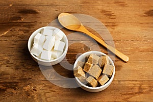 White and brown sugar cubes in white ceramic bowls