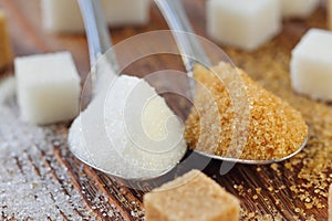 White and brown sugar in spoon