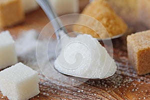 White and brown sugar in spoon