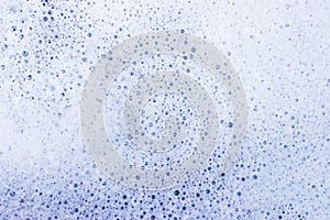 White bubble of detergent in blue container for background. Abstract texture