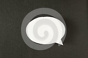 White bubble message from a paper on a black background, social network, symbol