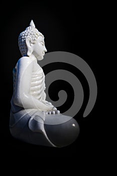 White Buddha statue with black background