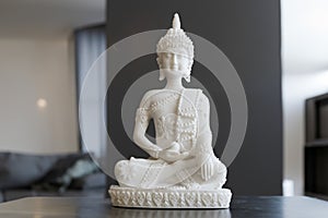 White Buddha statue in a contemporary home with neutral colors